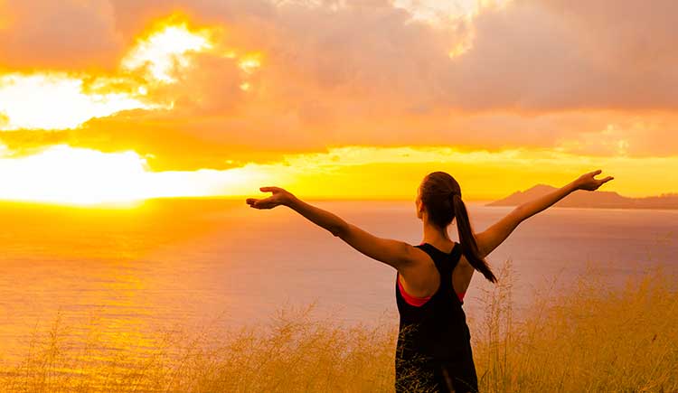 Girl embracing sunrise